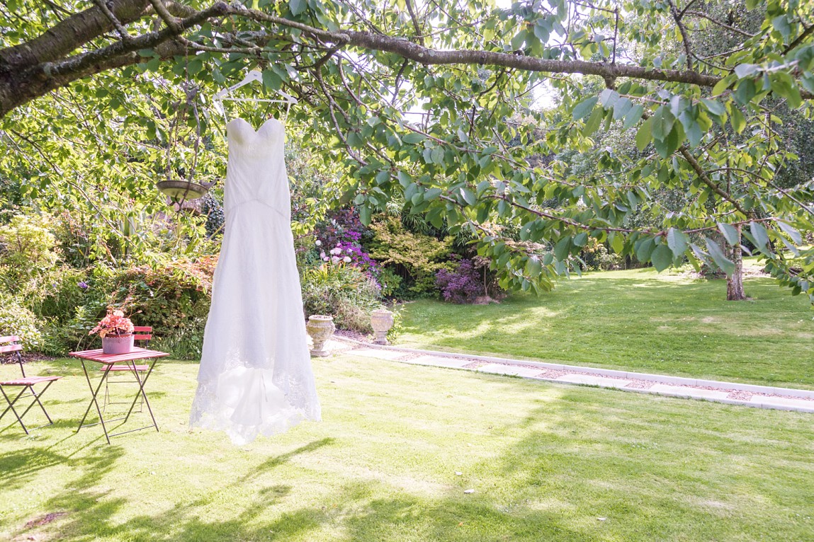 Wedding dress hanging from tree in garden