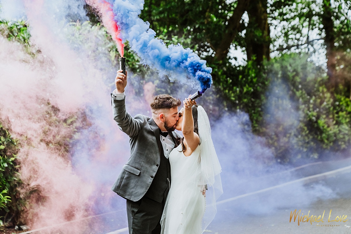 Wedding couple kissing and holding smoke bombs